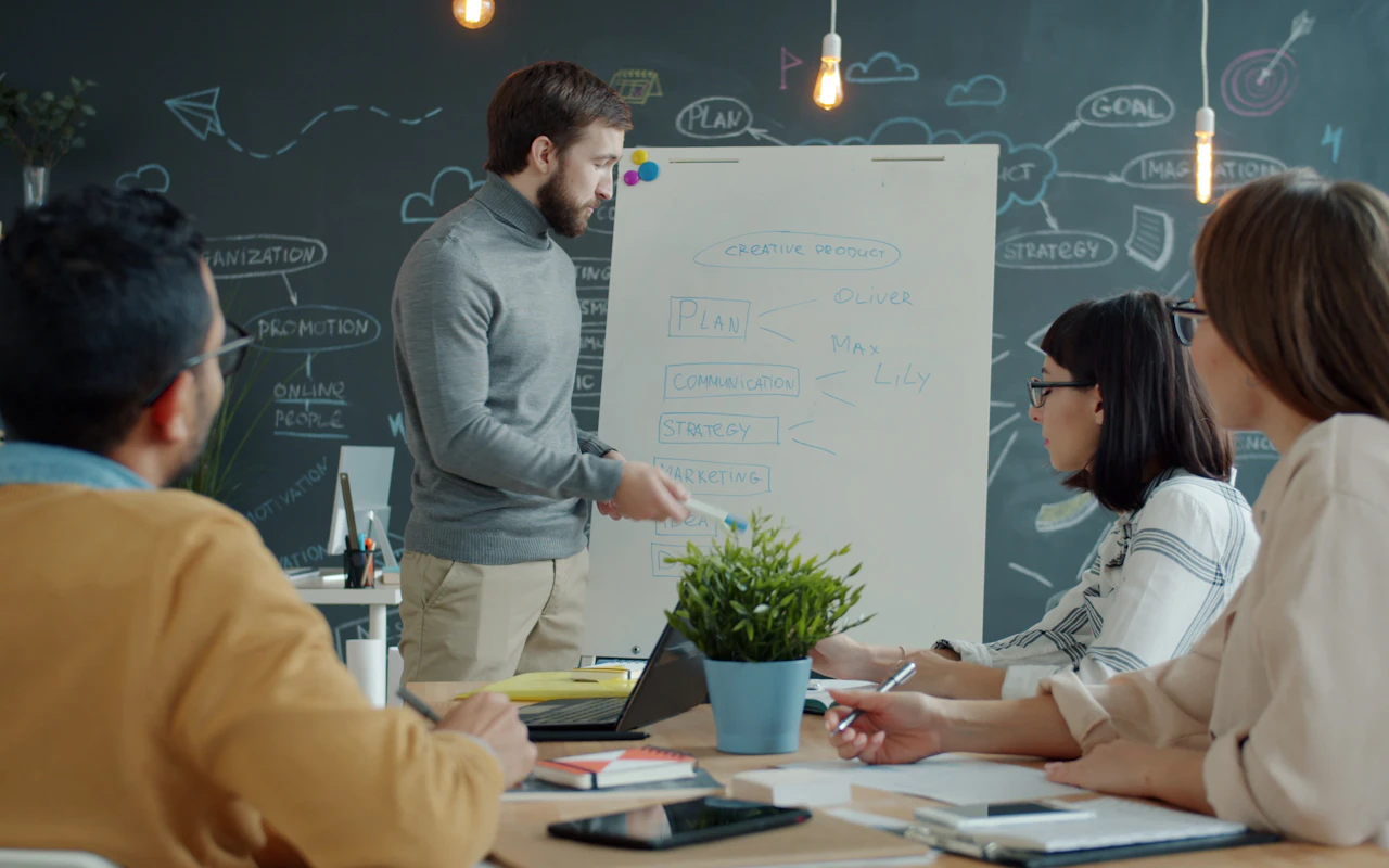 Colleagues discussing a plan at a whiteboard.